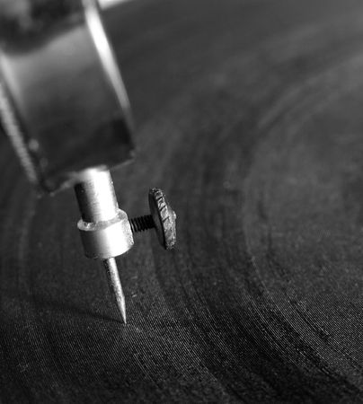 Extreme macro of the needle of an old-fashioned record player's needle in the grooves of a record.の写真素材