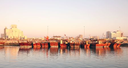 A line-up of dhows in Doha harbour, Qatar, at sunset, with the new Islamic Museum on the left (January 2007)の写真素材