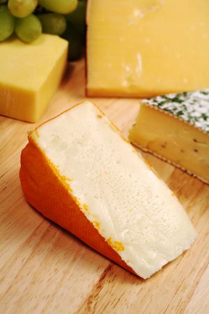 Port Salut cheese on a board with a variety of other gourmet cheesesの写真素材