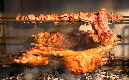 Pork, lamb and chicken grilling over the barbecue at a Greek taverna.の写真素材