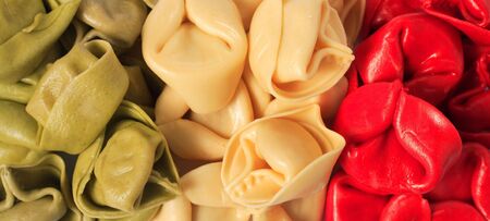 Coloured tortellini pasta shells arranged in the form of an Italian flag.の写真素材