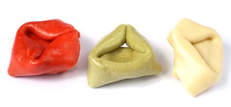 A macro photo of individual stuffed tortellini shells coloured red and green with natural ingredients and white..の写真素材
