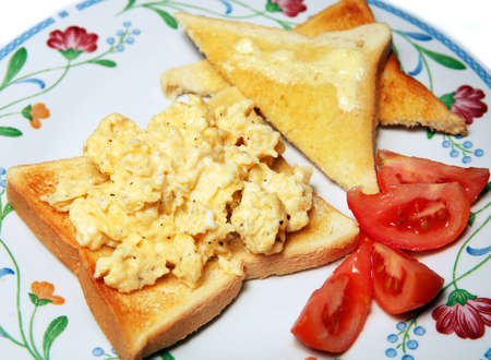 Scrambled egg on toast with a fresh tomato.の写真素材