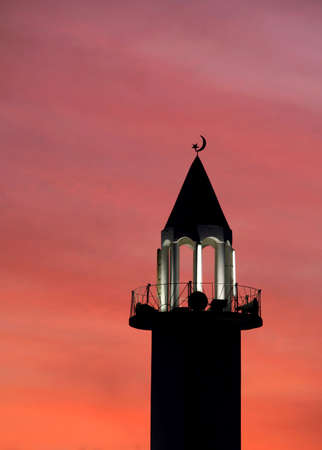 A mosque's minaret on Al Mirqab Street, Doha, Qatar, lit up at sunset for the Call to Prayer.の写真素材