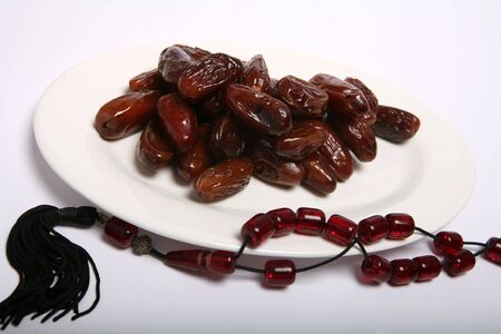 A plate of dates and prayer beads, two items which are strongly associated with the Muslim holy...