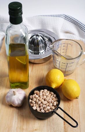 Ingredients required to make the classic mediterranean chickpea dip, hummus me tahini: olive oil, garlic, chickpeas, lemons and tahini (crushed sesame seeds)の写真素材