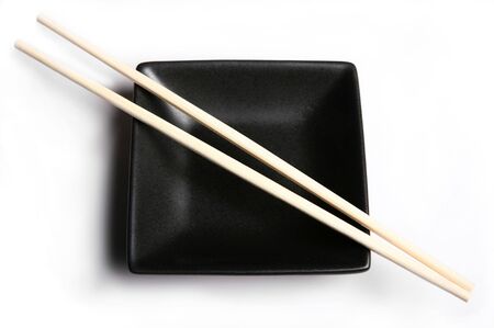 An empty, black authentic Japanese bowl with a pair of chopsticks, with a shadowの写真素材
