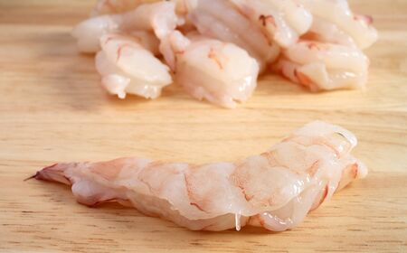 Close-up of raw prawns on a wooden chopping board.の写真素材