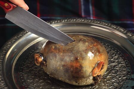 A haggis on a silver tray being cut, a highlight of a Burns Night supper following the 