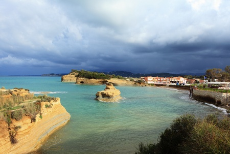 Eroding cliffs of bedded sandstone at the resort of Sidari, north Corfu, Greece, as a late afternoon storm moves in.の写真素材