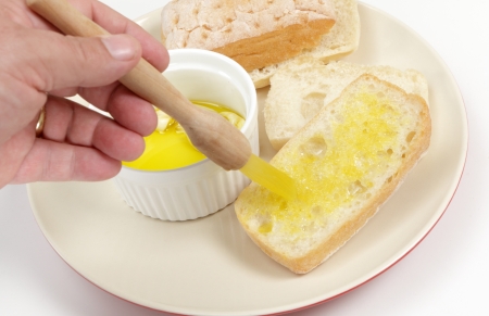 A piece of ciabatta italian bread being coated with garlic oil priot to toastingの写真素材