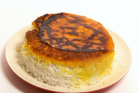 A plate of Persian rice, topped with a crust of pita and saffron colouring.の写真素材