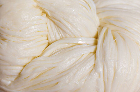 Macro showing the texture of braided string cheese, a popular type of cheese in southern Europe and...