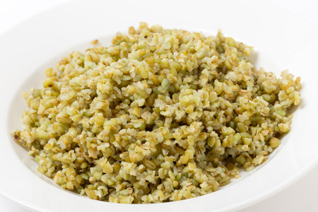 A bowl of freshly boiled cracked freekeh scorched green wheat grains, one of the "paleo superfoods". It can be eaten as it is or used in a wide range of dishes.の写真素材