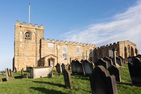 The church and graveyard of St Mary the Virgin, next to the ruins of Whitby Abbey, Yorkshire, UKの写真素材