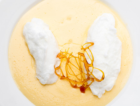 Floating islands, fluffy poached meringue on a lake of custard made from egg yolks, milk, sugar and vanilla, topped with a caramel framework. This is a traditional French farmhouse dessert.の写真素材