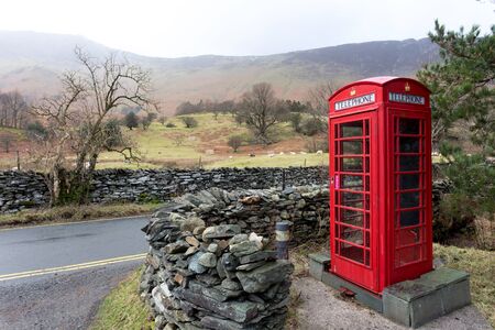 An iconic English telephone box in the Lake District National Park. The phone boxes were once important for communication but fell into disuse after mobile phones were invented.の写真素材