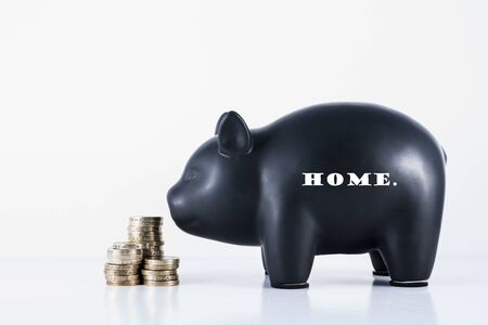 Black piggy bank and some coins with the motif - Homeの写真素材