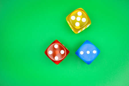 Colored casino-style dice with a green background from an overhead shotの写真素材