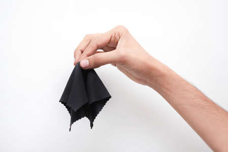 A man's hand holding a black handkerchief isolated on a white backgroundの写真素材