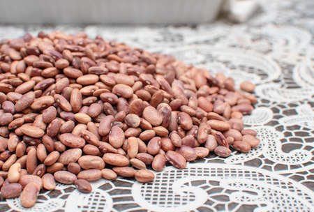 Pink pinto beans spread out on a table with a white tablecloth