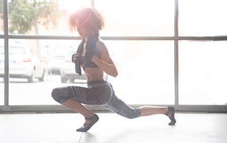 Young and Beautiful woman doing stretching after workout on the floor in the gym. Horizontal