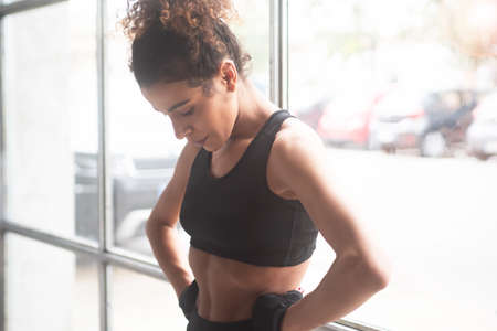 Close up of a young and beautiful woman having relax after workout in a gym isolated. Horizontalの写真素材