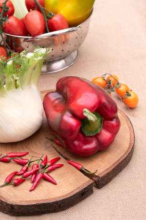 Fresh and various vegetables, peppers fennel celery and tomatoes on a wooden table. White background. Verticalの写真素材