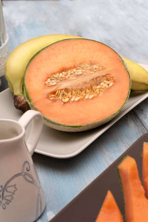 Fresh and various fruits isolated in a shabby chic background. melon and bananas. Vertical view from the topの写真素材