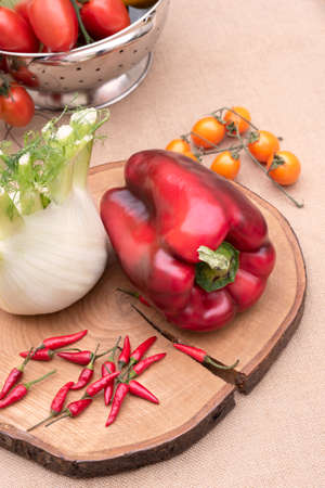 Fresh and various vegetables, peppers fennel celery and tomatoes on a wooden table. White background. Verticalの写真素材