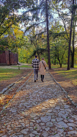 Young couple walking in the park in autumn season. Back view.の写真素材