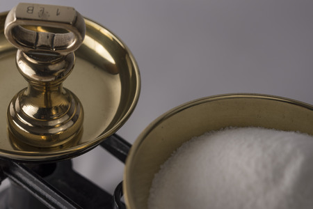 Sugar being weighed out on an old pair of balanced scalesの写真素材