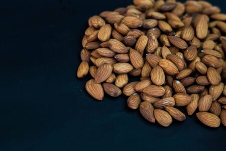 close up almonds nuts on black background,selective focus.の写真素材