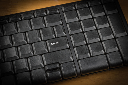 enter button of black keyboard on wooden table ,selective focus.の写真素材