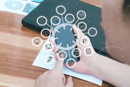 business technology concept,Business people hands use smart phone connection online networking communication on table with social network icon symbol,selective focus.の写真素材