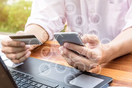 business money concept : man hand holding credit card using online paying banking on smart phone...