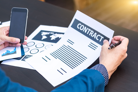 business insurance lawyer concept : hand using pen sign business contracts agreement paper ,selective focus.の写真素材