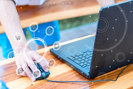 business technology concept,Business people hands use smart phone and laptop connection online networking communication on table with social network icon symbol,selective focus.の写真素材