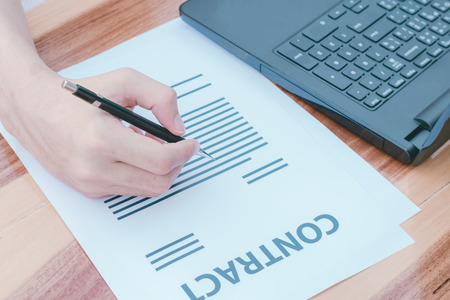 business insurance lawyer concept : hand using pen sign business contracts agreement paper...