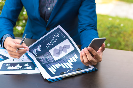 business technology concept,Business people hands use smart phone connection online networking communication on table ,selective focus.の写真素材