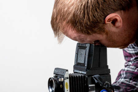 Manchester UK March 2021 man using old film camera looking down waist level view finderの写真素材
