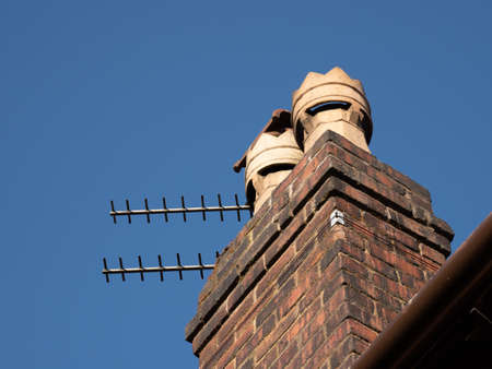 Chimney pots on top of a house roof UK clear blue sky copy spaceの写真素材