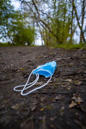 discarded face mask left on the footpath in the woods covid protectionの写真素材