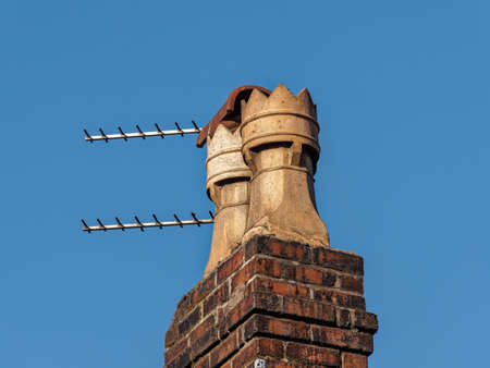 Pair of chimney pots and television Ariel UK clear blue skyのeditorial素材