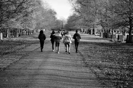 group of young adults walking along footpath in country parkのeditorial素材