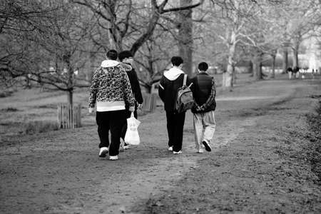 group of young adults walking along foot path in country parkのeditorial素材