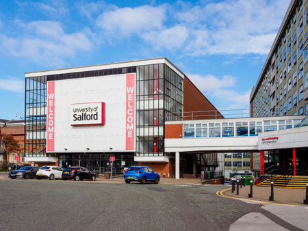 Salford, Manchester, UK. September, 28, 2024: Modern university building with a welcoming sign under a bright blue sky.のeditorial素材