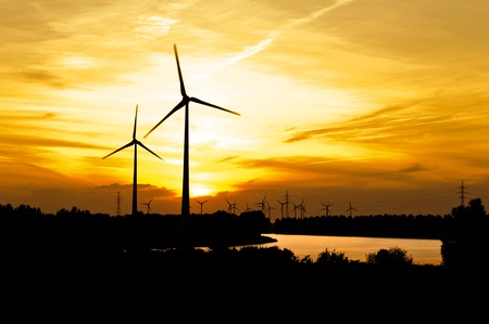 Silhouette of wind turbine farm over sunset の写真素材