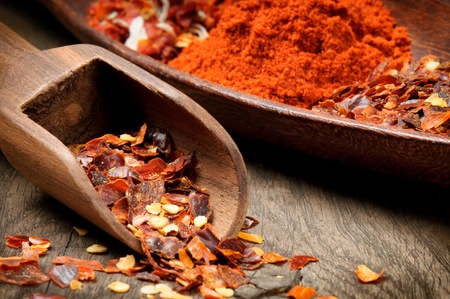 Red hot chili flakes and powder with wooden scoopの写真素材