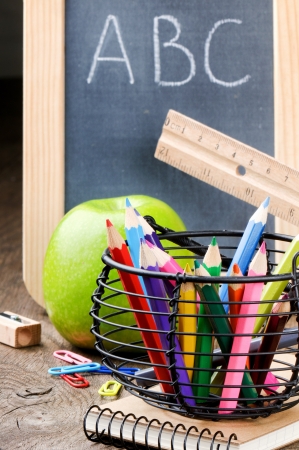 Chalkboard and colorful crayons on wooden deskの写真素材